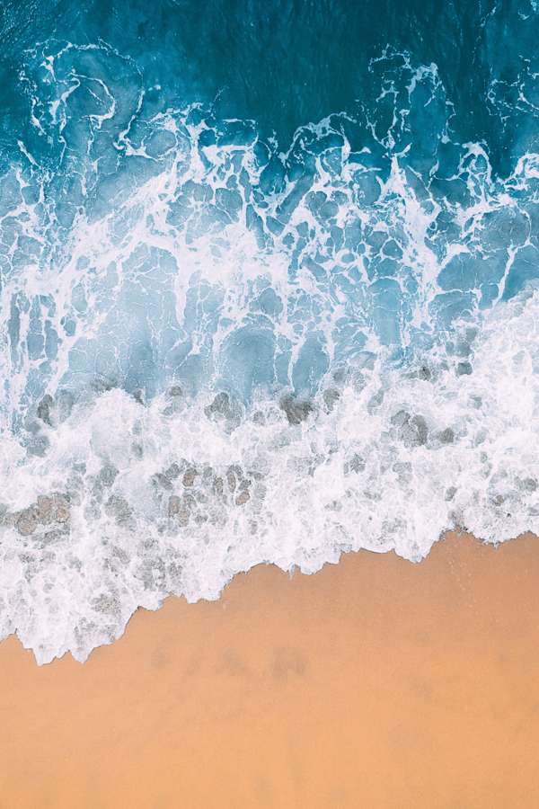 An arial shot of the sea coming up onto the sand. 