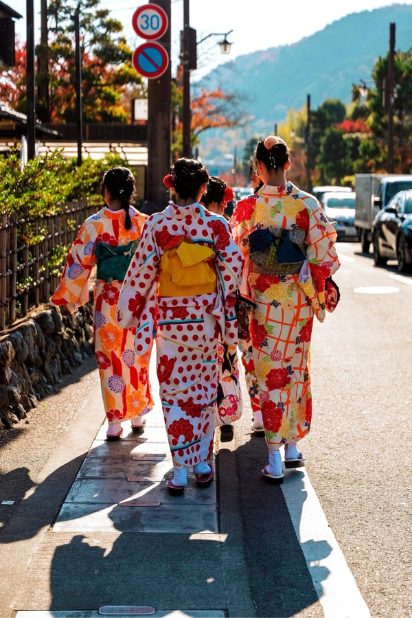 Women in traditional japanese clothing walking down a road in Kyoto, Japan.