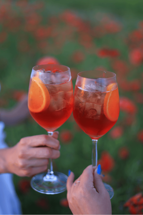 A couple enjoying an Aperol spritz outside. 