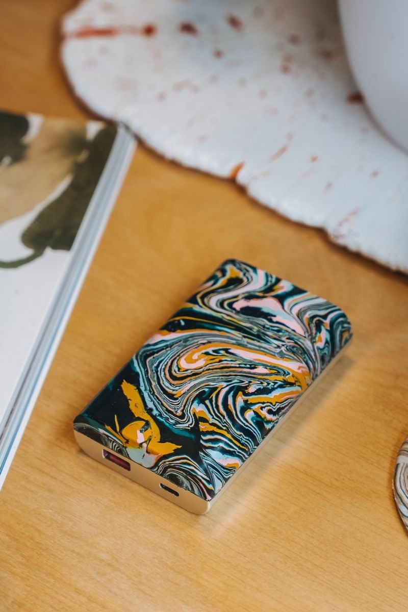 A colourful Gomi powerbank sitting on a desk. 