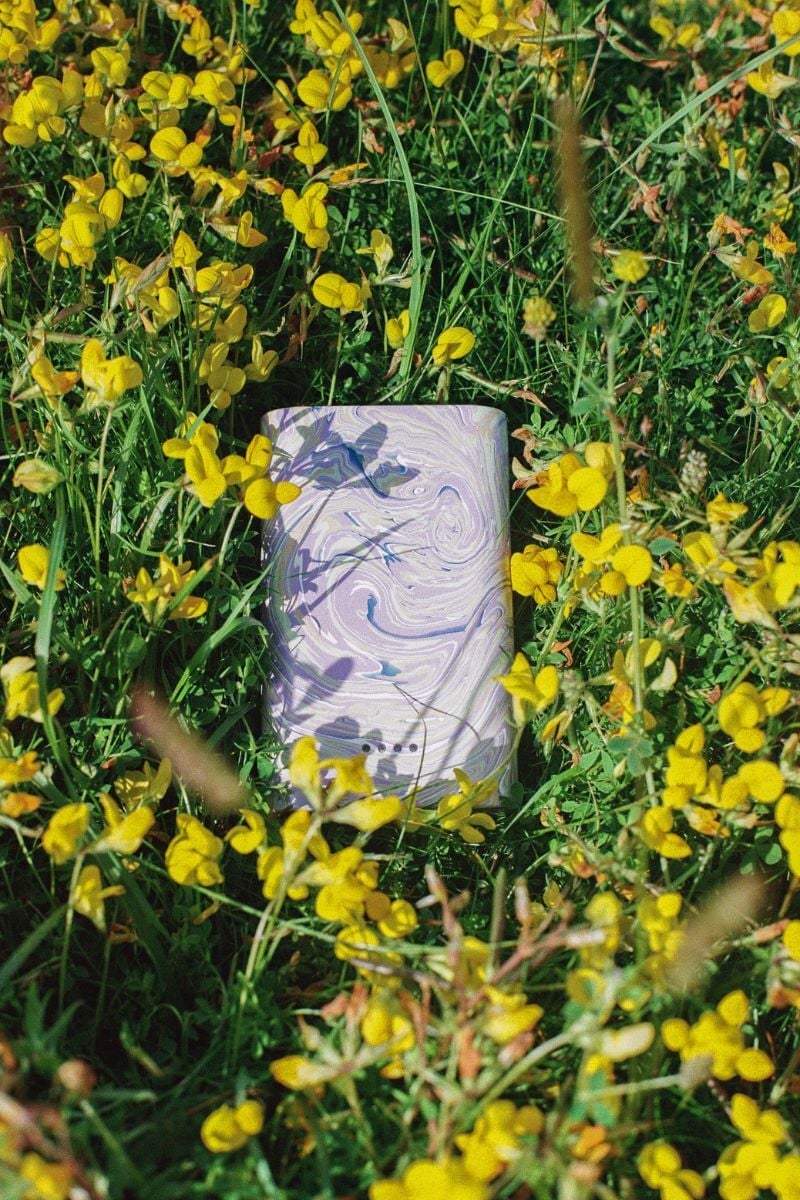 A Gomi powerbank sitting in a field of buttercups.