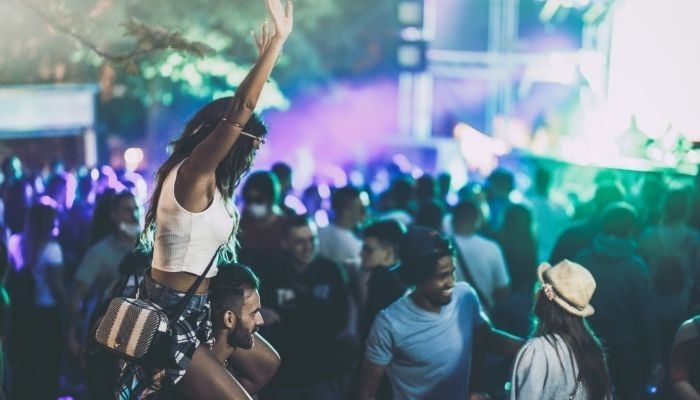 Return on Emotion in action - people enjoying a festival with a girl on a man's shoulders. 
