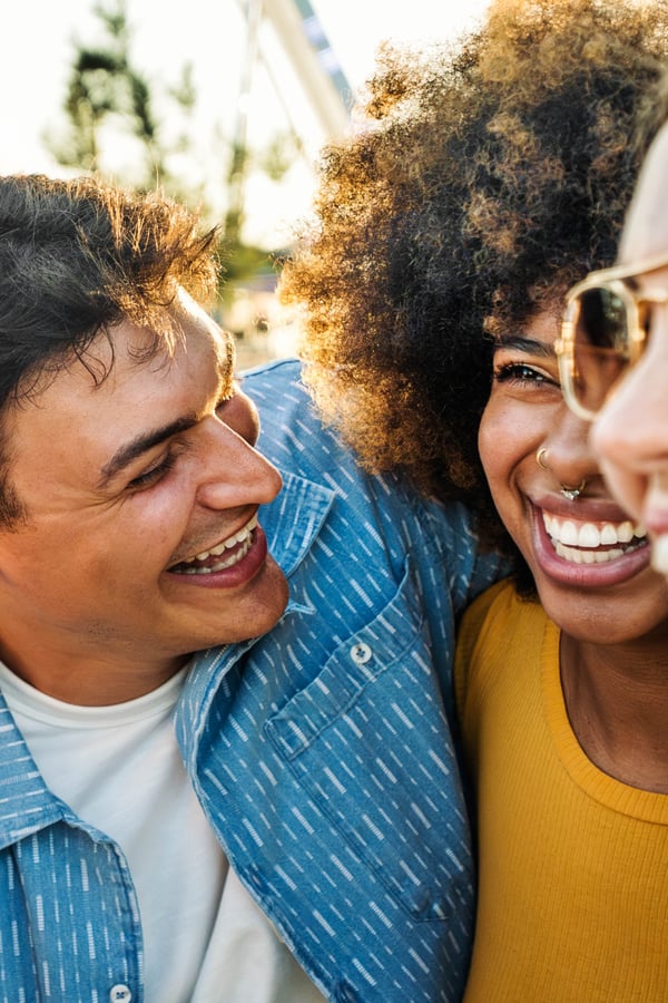 A group of friends hugging, smiling and laughing. 