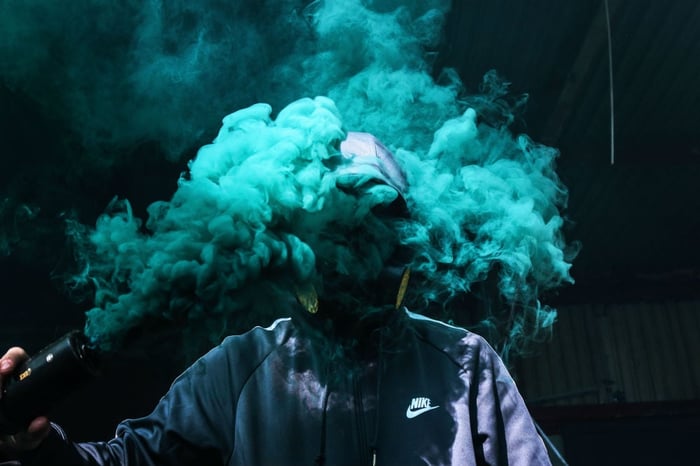 photo-of-person-holding-teal-smoke-grenade