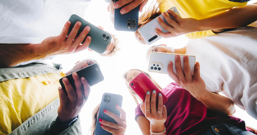 A circle of people looking at their phones. 