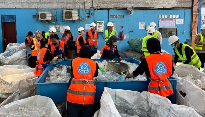 Employees of Prevented Ocean Plastic sorting through the plastic pollution that's been brought in for recycling.