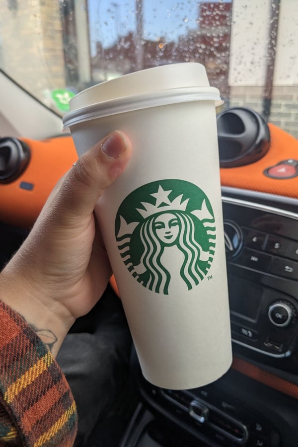 Natasha holding a Starbucks PSL (Pumpkin Spice Latte). 