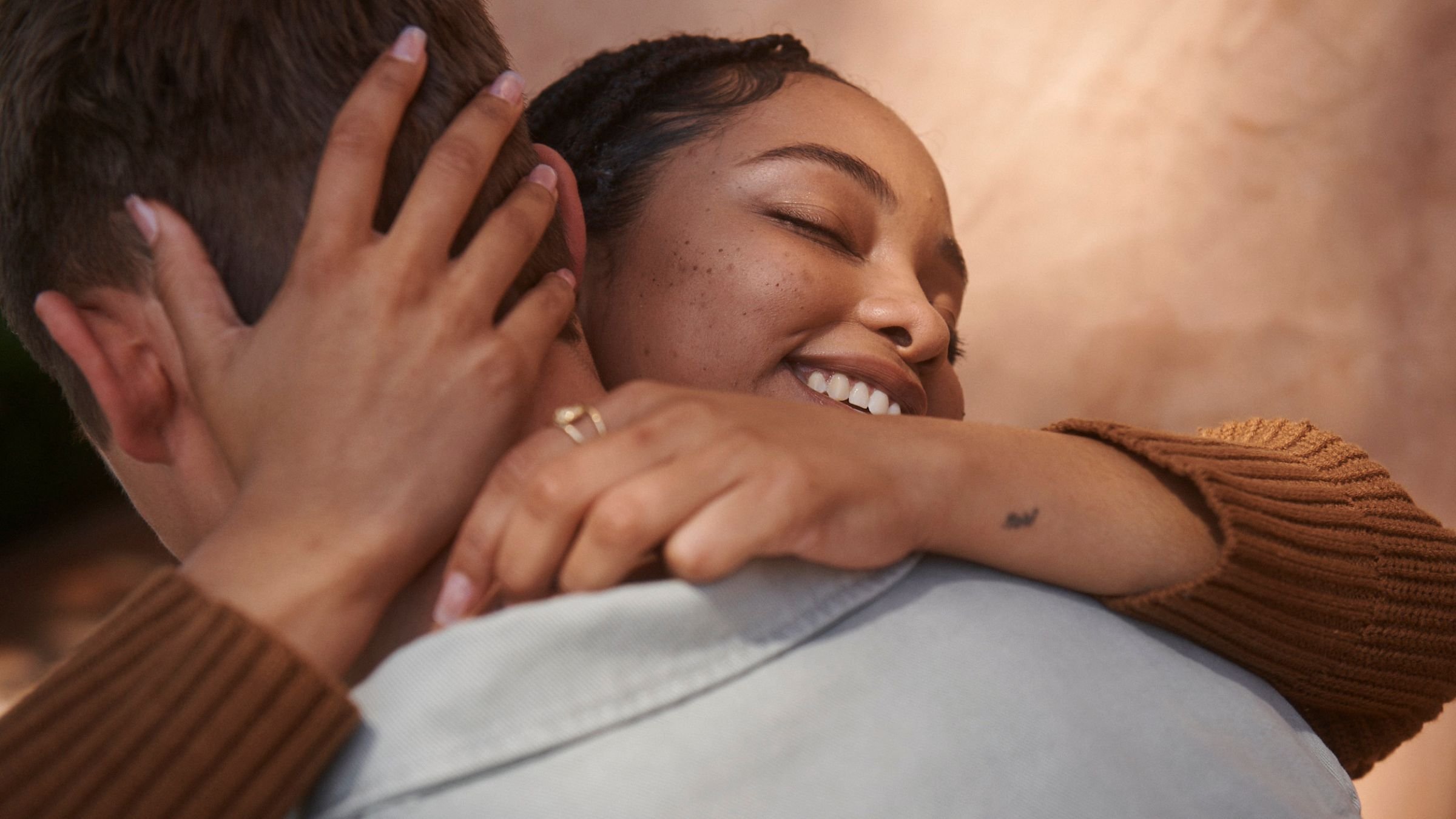 A couple who met on Hinge hugging.