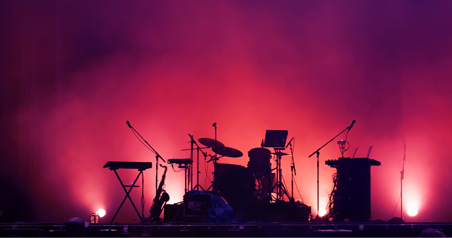 Band set up on stage with dark pink lighting