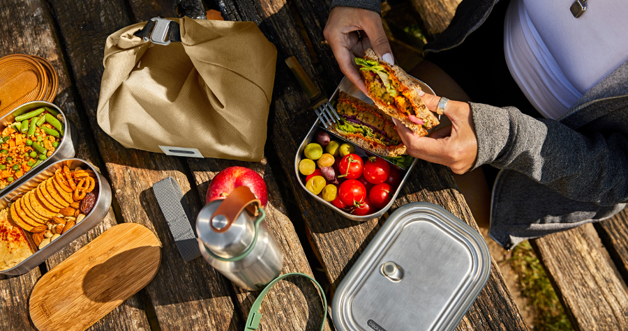 Someone eating a packed lunch out of Black+Blum's stainless steel lunchbox outside