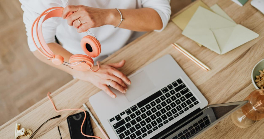 image of a person using a laptop and headphones, with the best tech on the table