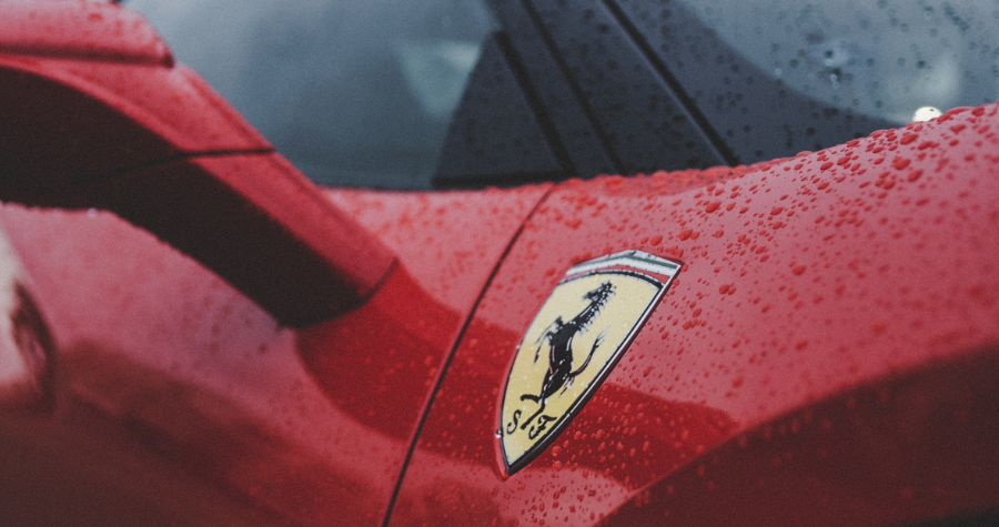 A close-up photo of the Ferrari logo on a red car. 