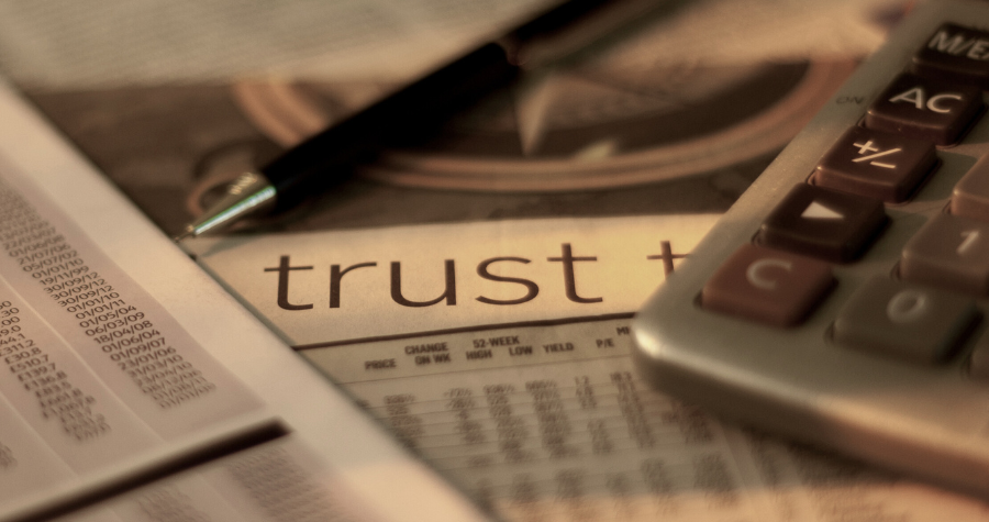 An office desk showing a work calendar with the word 'trust' at the top of it.