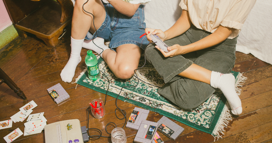 Two friends in the 90s playing old video games.